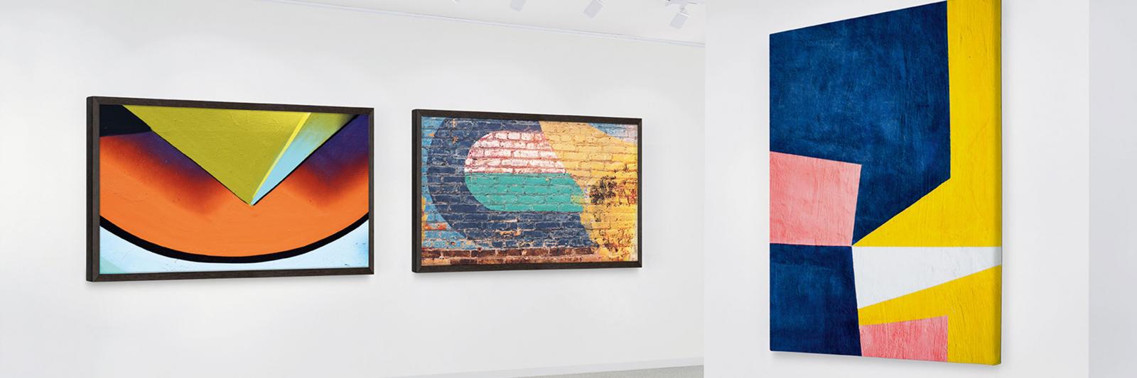 Photo und Art, bedruckbare Künsterleinwände und Fotopapiere drei farbige Kunstreproduktionen an der Wand einer Galerie